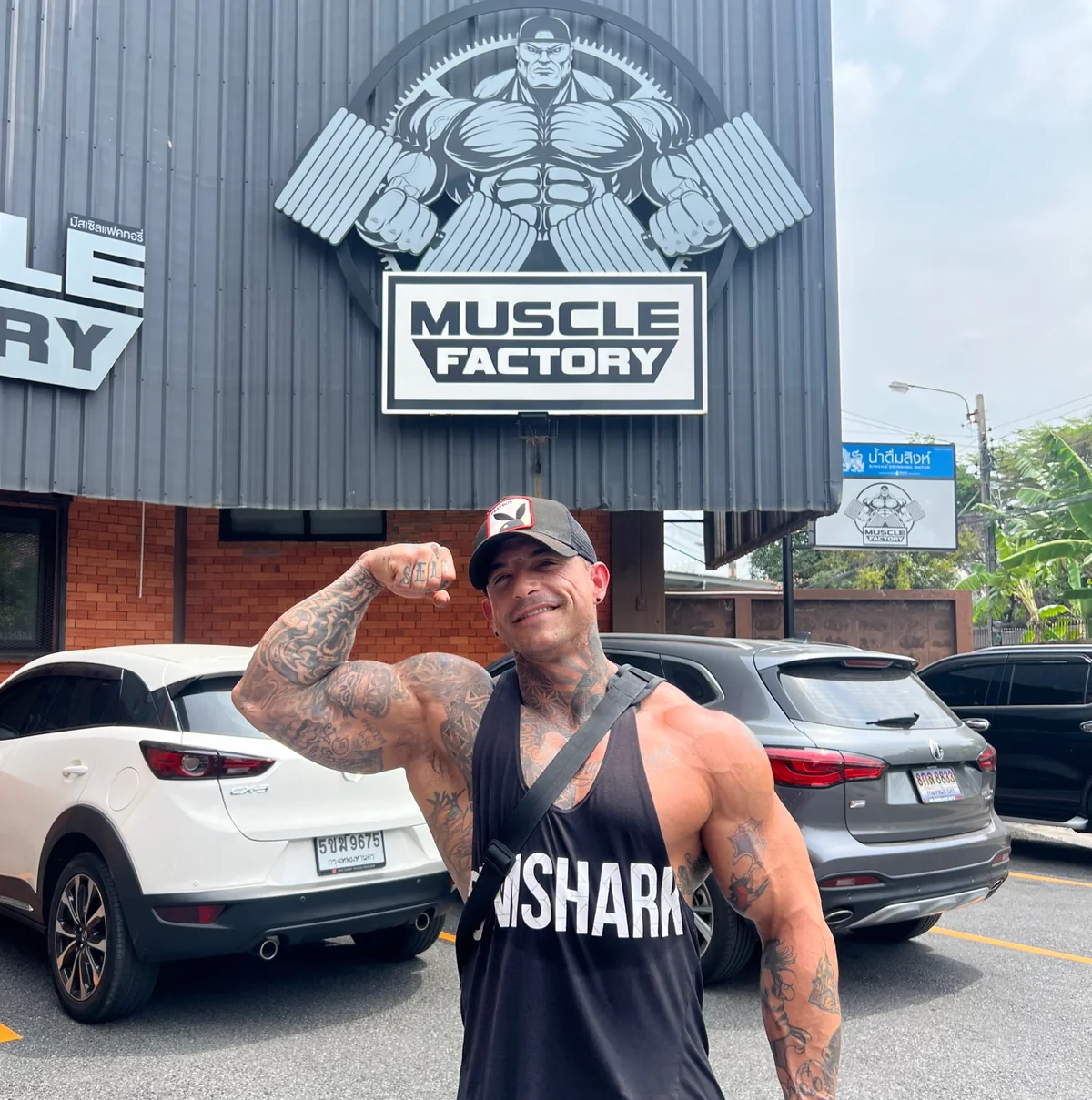 Coach Justin Cox, 42, flexing outside the Muscle Factory gym