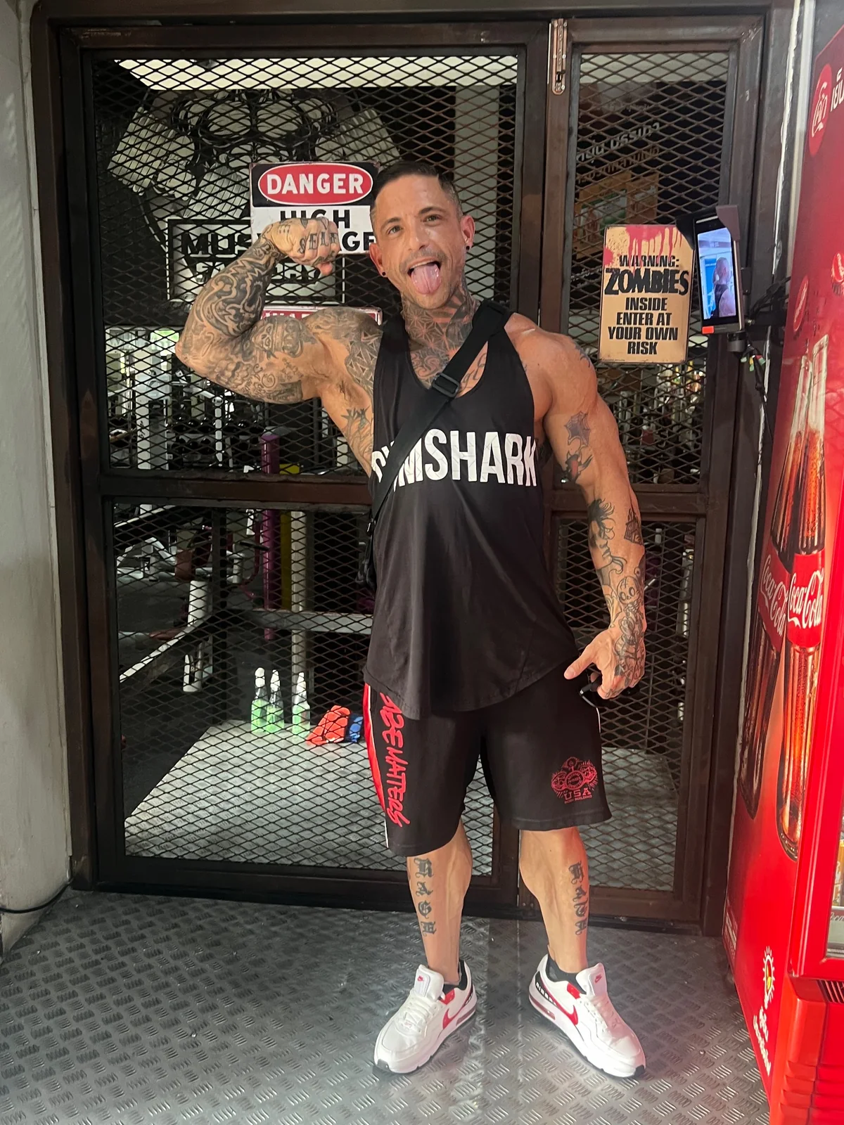 Justin Cox, BodieZ By J coach, flexing outside a gym in Thailand — keeping muscle while living and training abroad