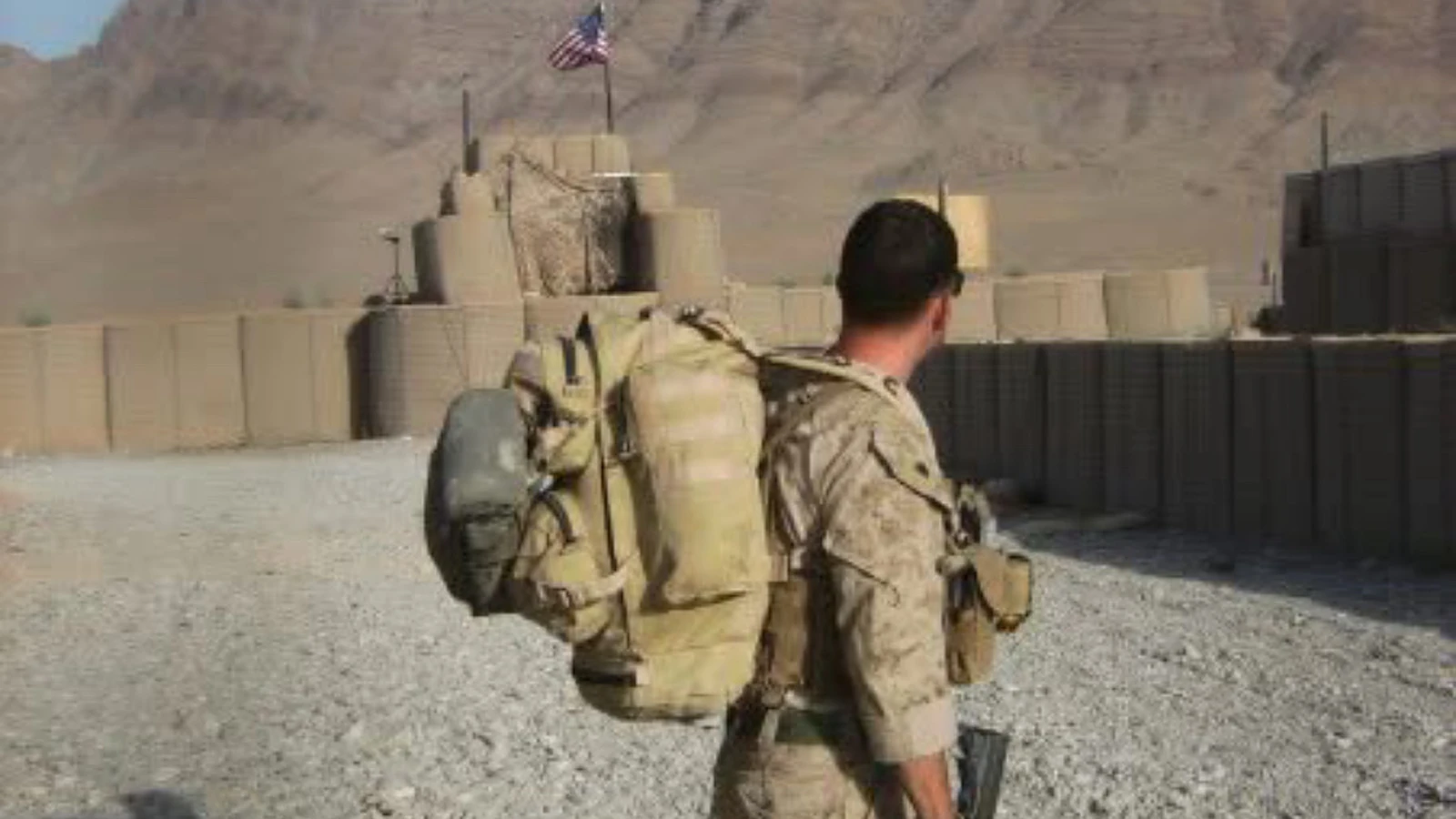 Justin Cox, former U.S. Marine, carrying a full combat pack and rifle at a forward operating base in Afghanistan